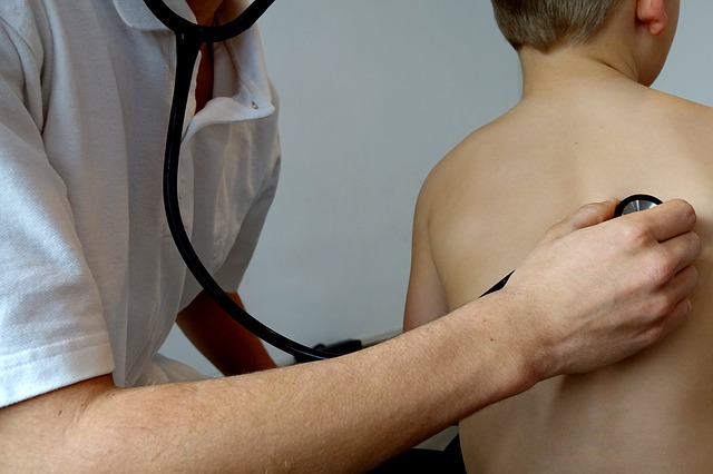 Doctor listening to child's chest with stethoscope