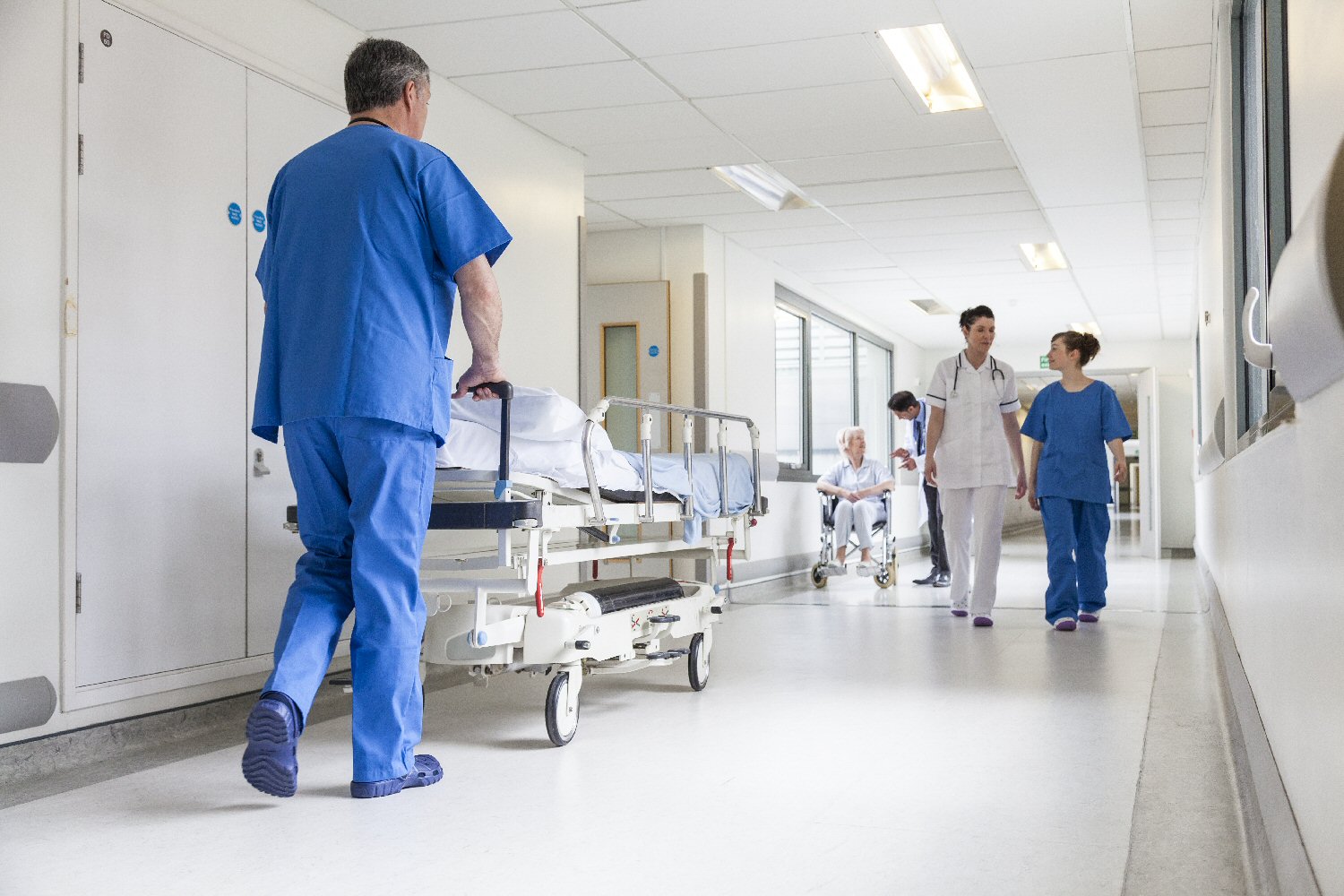 Nurses And Patients In Hospital Corridor